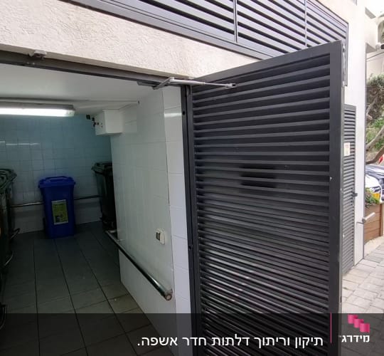 דלת מתכת פתוחה ליד פחי אשפה ירוקים